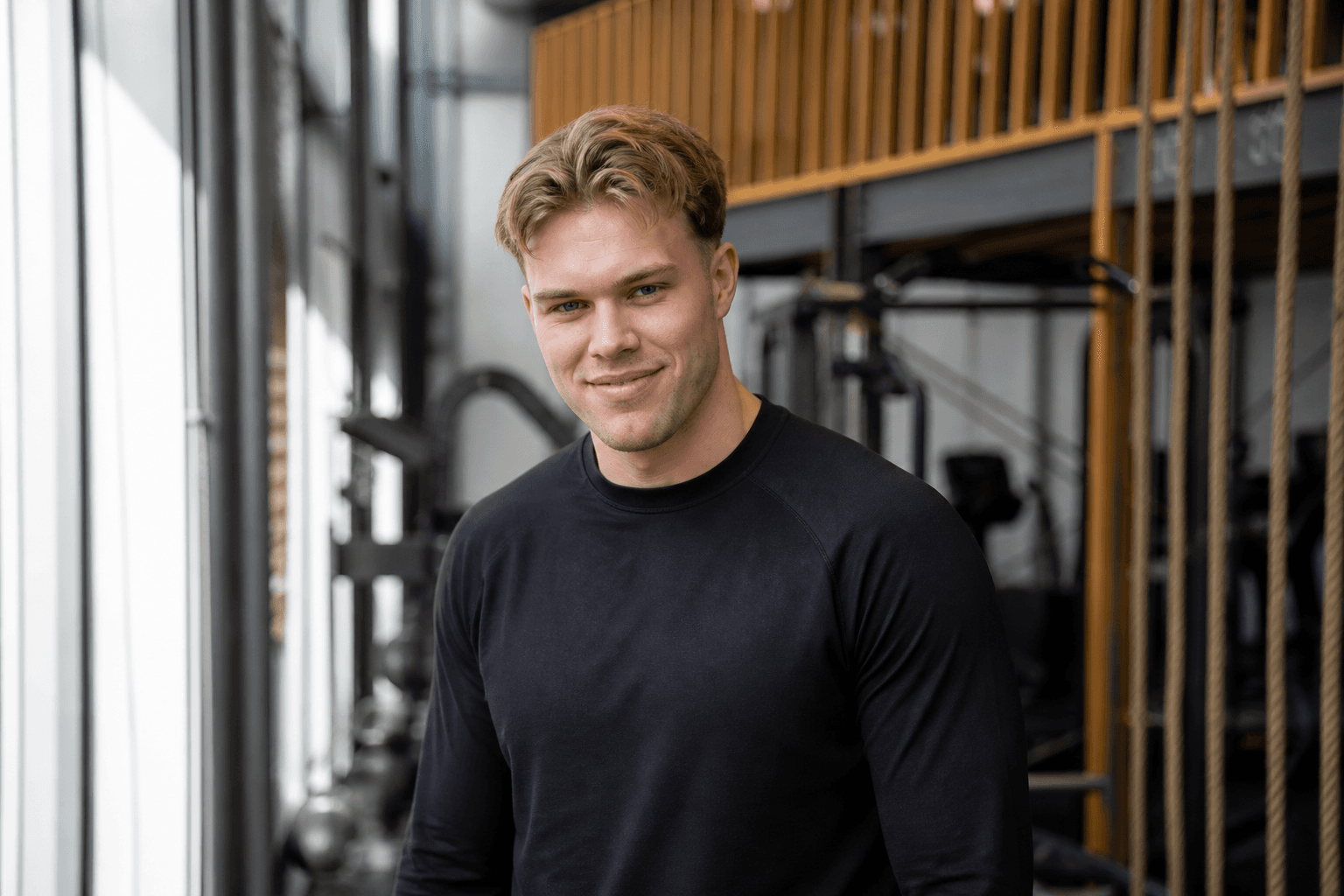Portret van Julius Roters in de sportschool, zwart trainingsshirt, lichtbruin haar achterover, rustige blik
